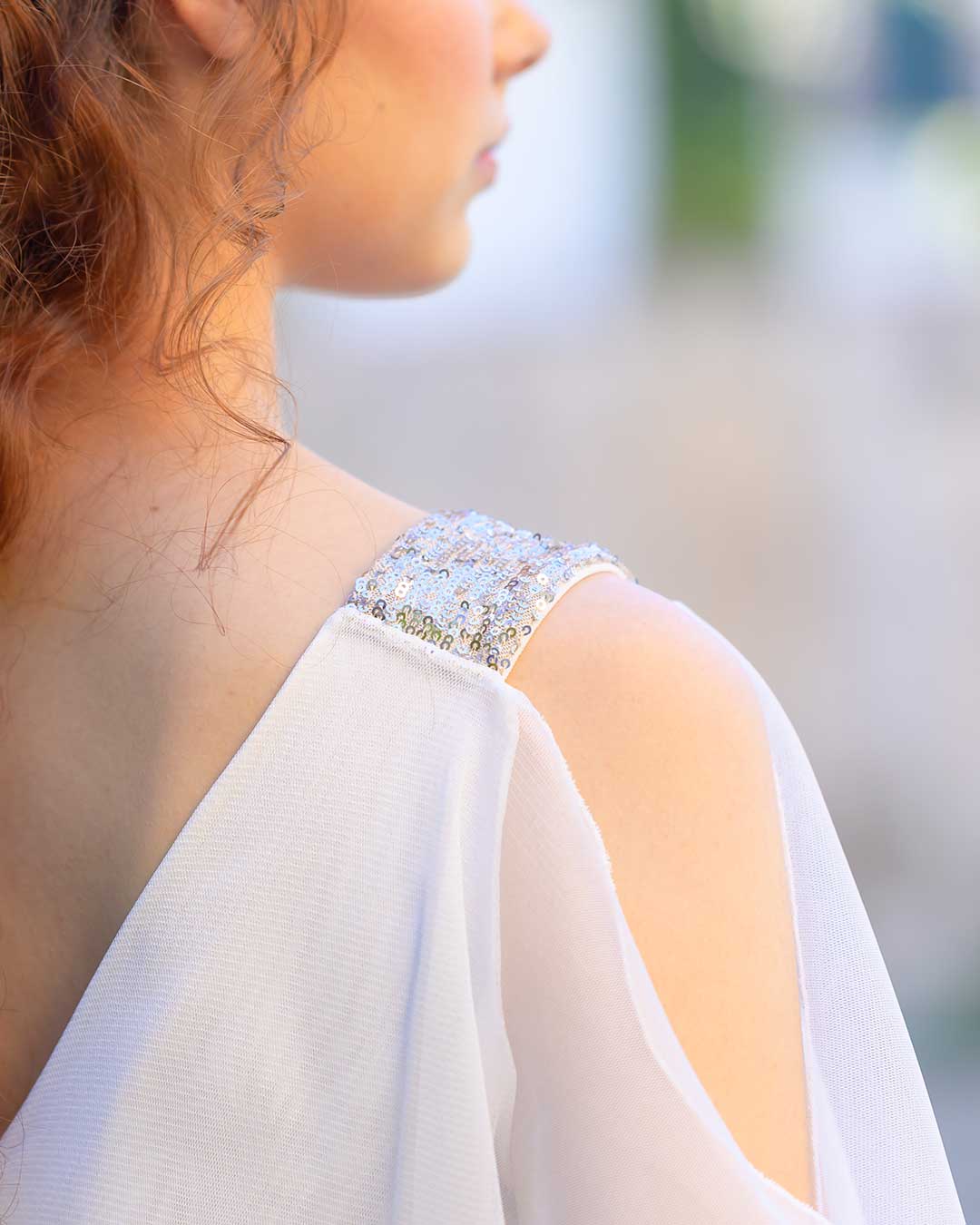 Detalles del vestido blanco en el hombro, hecho de lentejuelas.