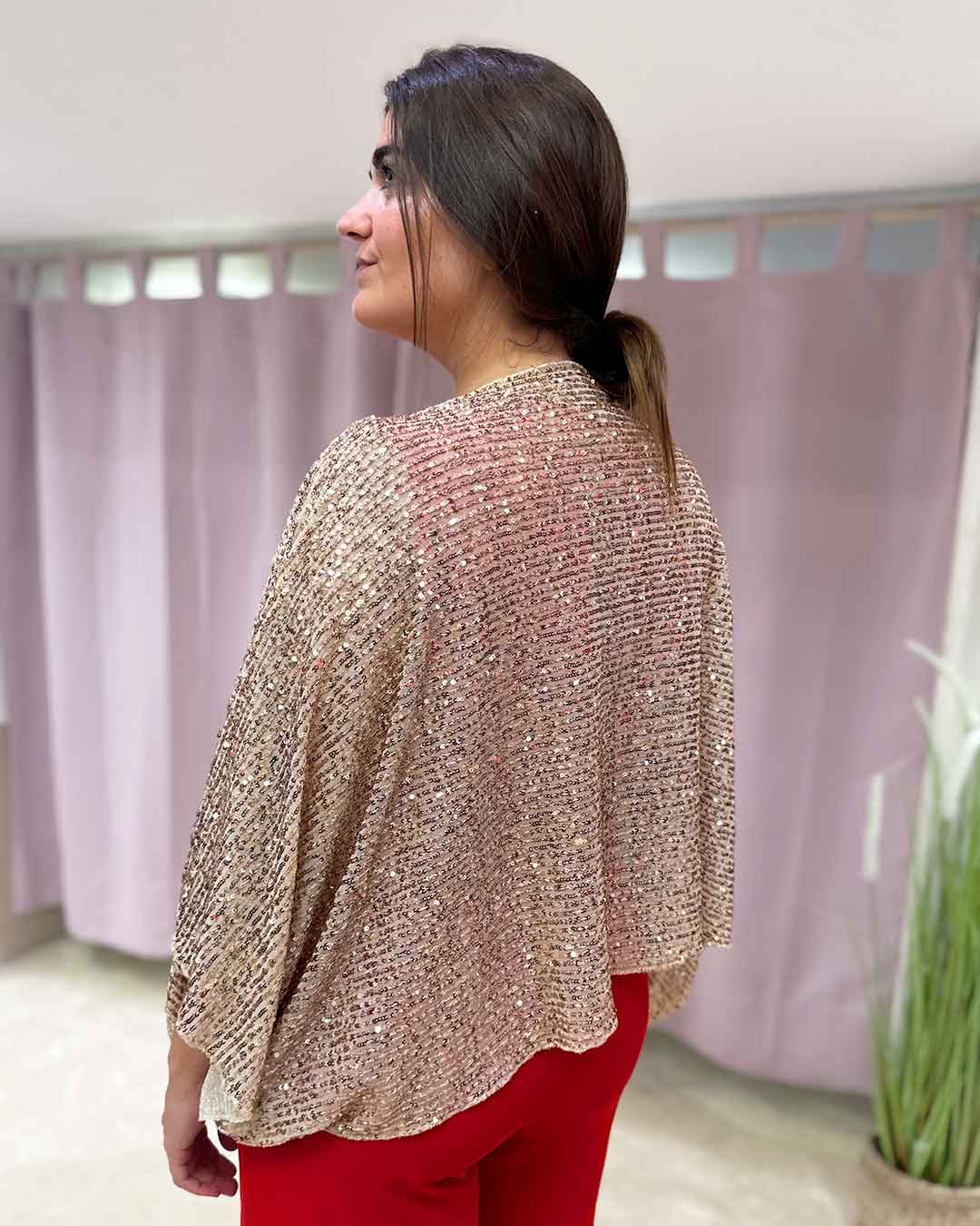 Espalda de capa estilo poncho dorado de lentejuelas.