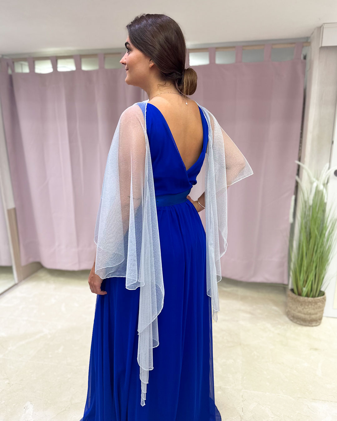 Parte trasera de chal color plateado, puesto con elegancia para estilizar el outfit de invitada de boda.