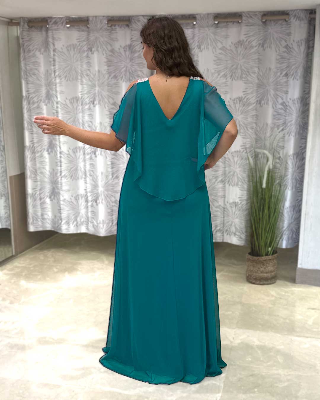 Espalda de vestido de fiesta. Con capa de gasa color verde pato y tirantes anchos plateados de lentejuelas.