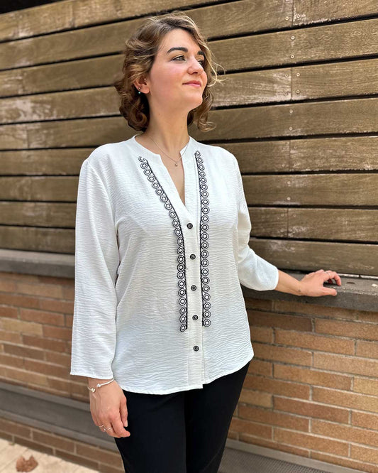 Camisa blanca con textura rústica, escote con solapas y aplique de círculos vertical. Perfecta para ir elegante a una cena casual.