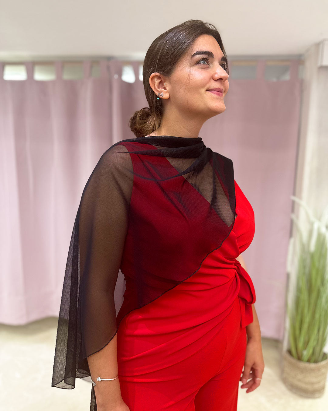 Chal color negro, puesto de forma asimétrico sobre los hombros de la modelo, combinado con un mono rojo de invitada de boda.