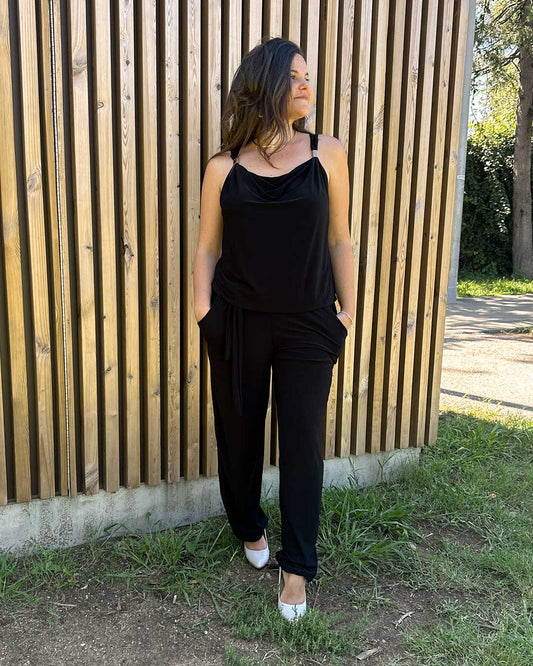 Modelo luciendo un elegante mono con apliques, en un tono sobrio y sofisticado, que resalta su diseño cómodo y ajustado. Ideal para eventos especiales.