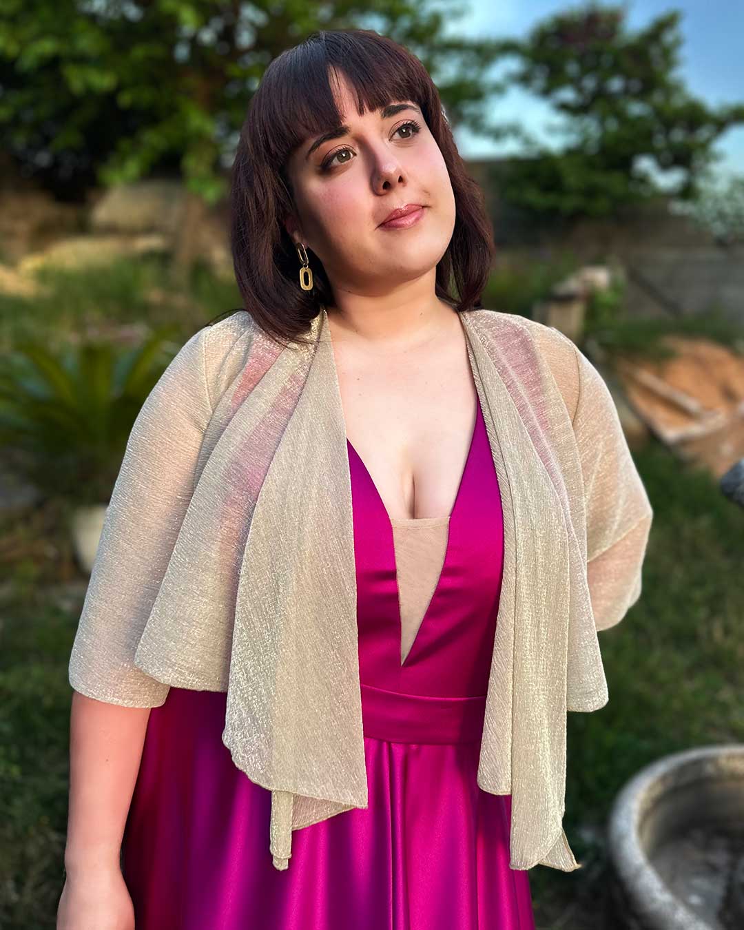 Chica lleva puesto bolero plateado que tapa sus brazos y estiliza su figura. Perfecto para fiestas e invitadas de boda.